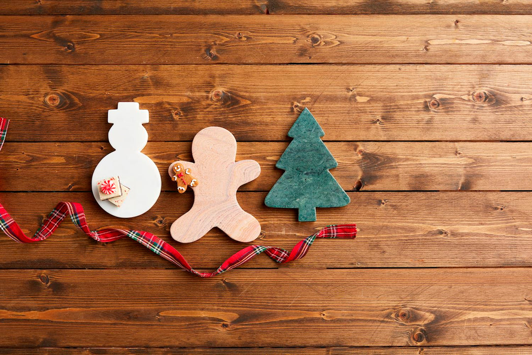 Snowman, gingerbread man, and pine tree-shaped marble serving boards.
