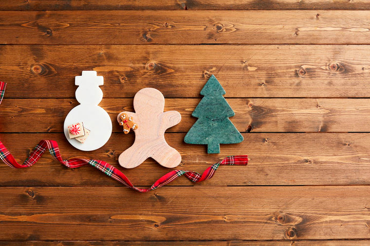 Snowman, gingerbread man, and pine tree-shaped marble serving boards.