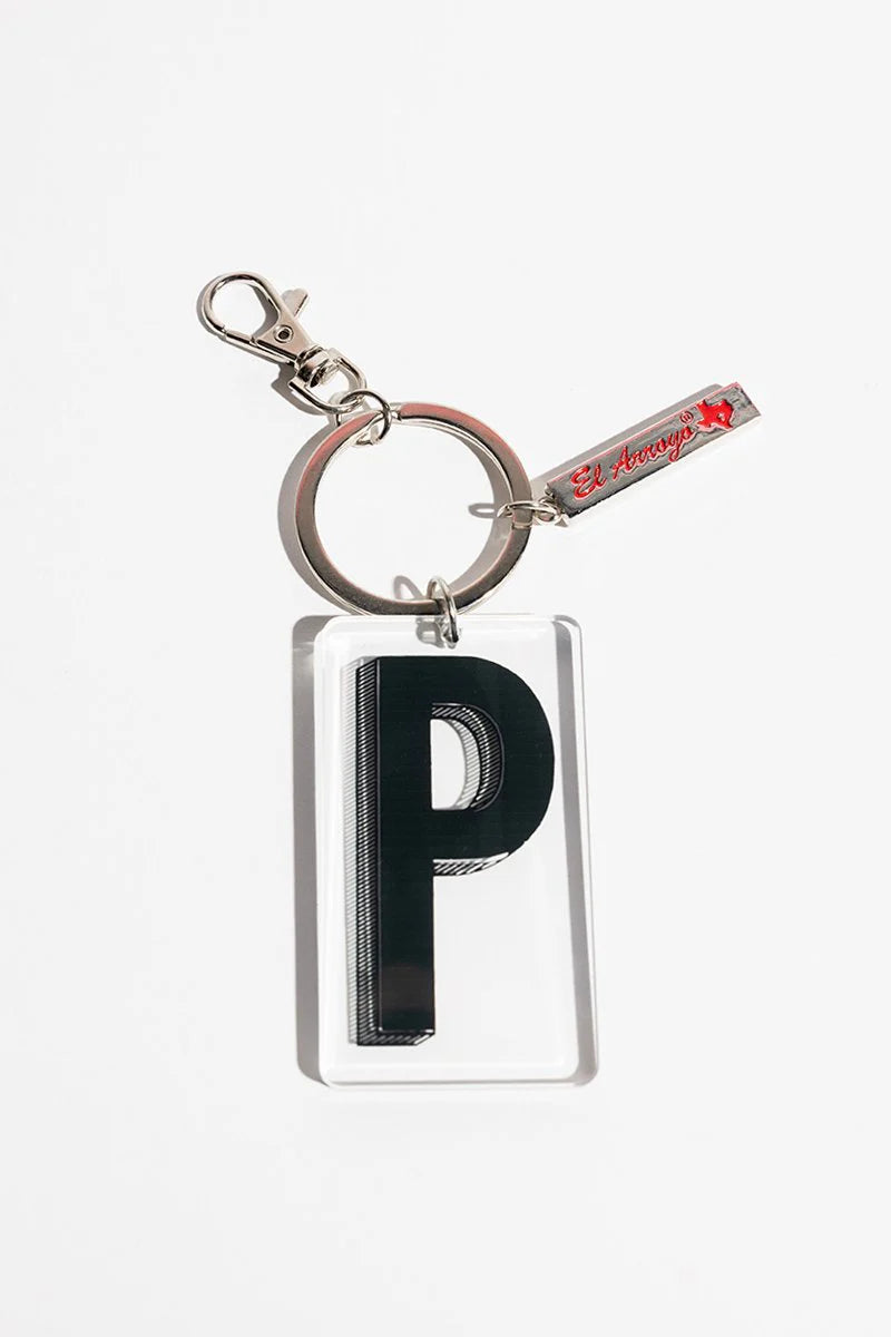 Clear acrylic keychain with bold black "P," metal "El Arrayán" tag, red graphic, sturdy ring. Available in one size.