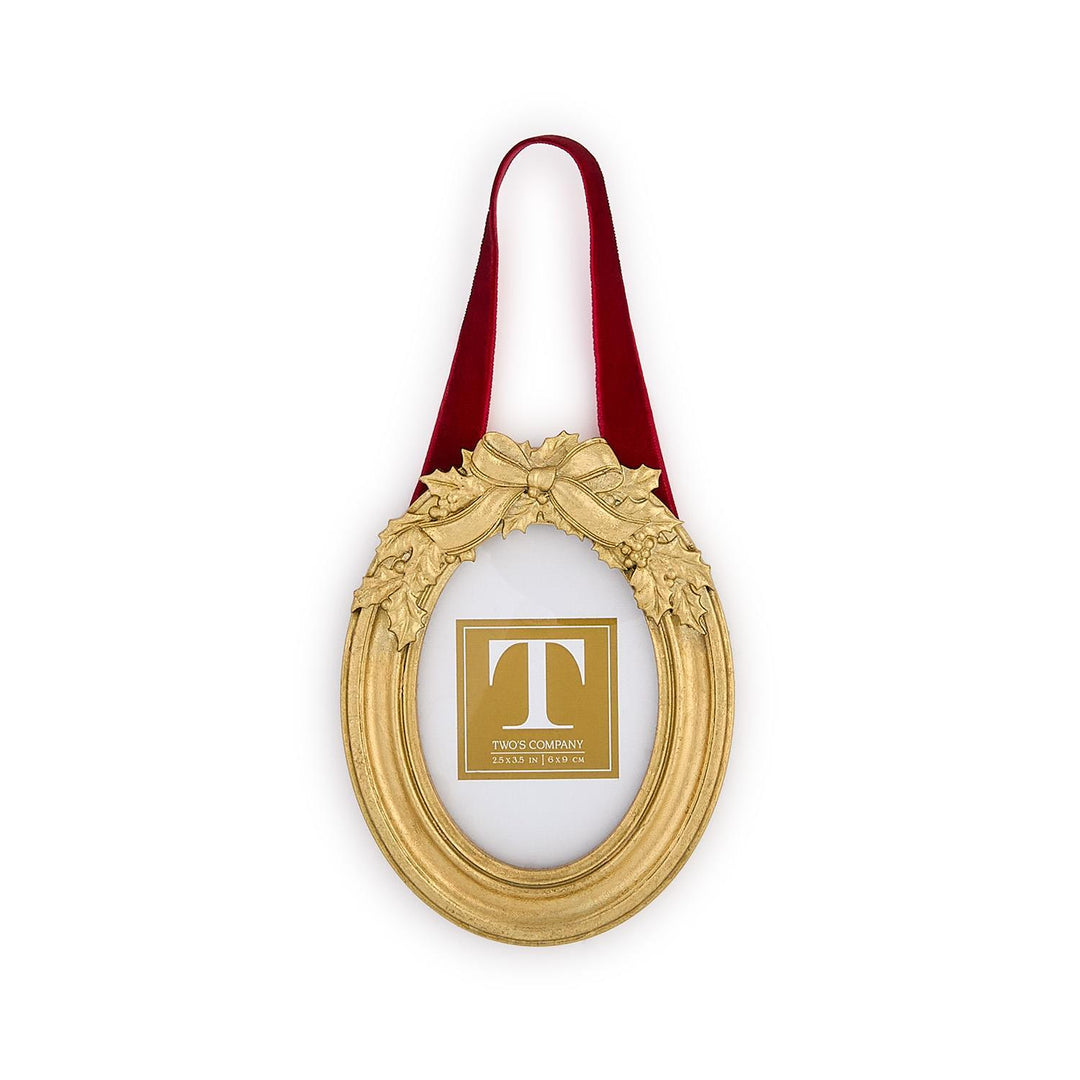 Holly Leaves Ornament Photo Frame, oval gold frame with holly leaves and ribbon bow, hanging from red velvet ribbon, for 2.5 by 3.5 inch photo.