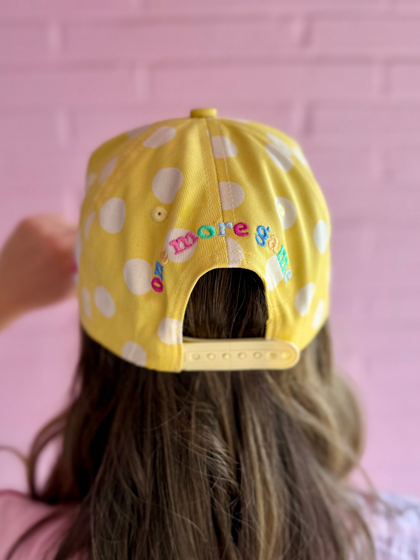 Dot Crack Bam Hat: adjustable yellow snapback with polka dots and colorful "one more game" embroidery. Sizes: S/M, L/XL.