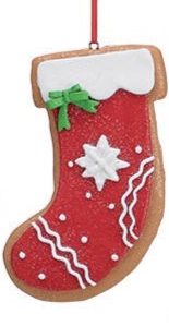 Clay dough stocking-shaped gingerbread ornament with red glitter, white cuff, green bow, and white piped icing.