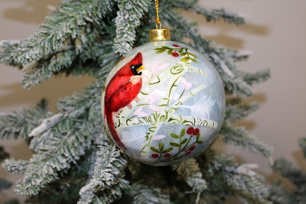 Cardinal Capiz ball ornament featuring a red cardinal on a branch with berries.