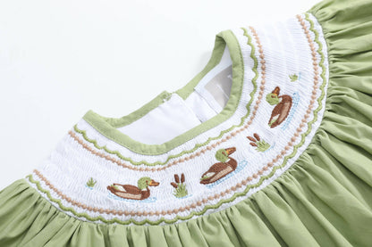 Pistachio Green Mallard Duck Smocked Bishop Dress in size 4T, featuring green fabric and a white smocked collar embroidered with ducks, cattails, and grass in brown, green, and blue thread.