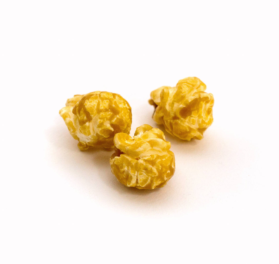 Salted Caramel Popcorn with a glossy, golden-brown coating and textured surface. Available in small, medium, and large sizes.