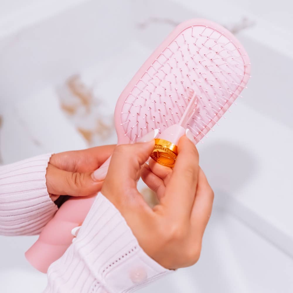 Medium bubblegum pink Detangler Brush with integrated gold-capped tool.