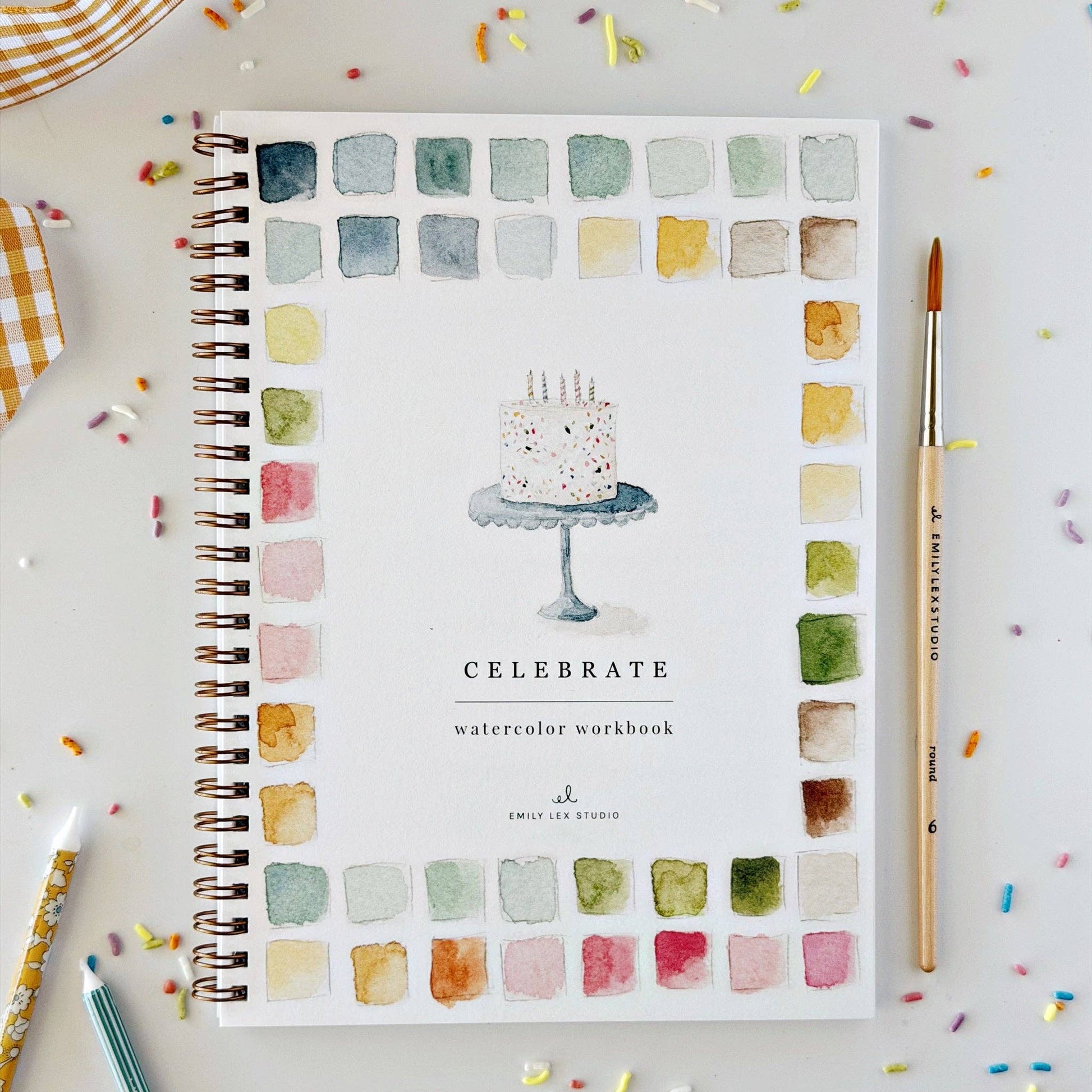 Celebrate Watercolor Workbook is spiral-bound with a cake illustration and vibrant paint swatches on the cover. Filled with festive party illustrations for beginner painting. Sizes available: not specified.