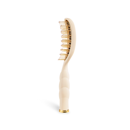 The Vented Hair Brush | Tan is a beige brush with gold bristles, a curved ergonomic handle, and a quick-heat aluminum plate. Sizes available: not specified.