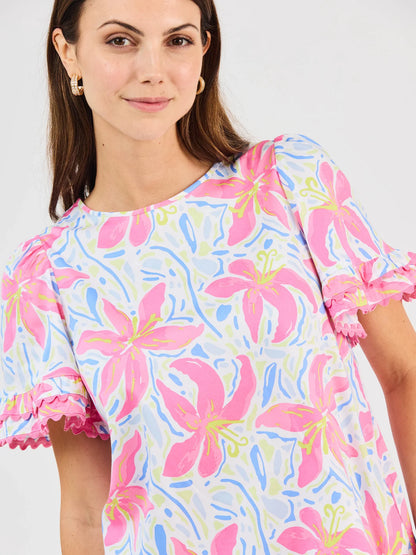 Cassidy Hibiscus Harmony White Top: short sleeves, crew neck, pink floral print, ruffled edges. Sizes XS-XL.