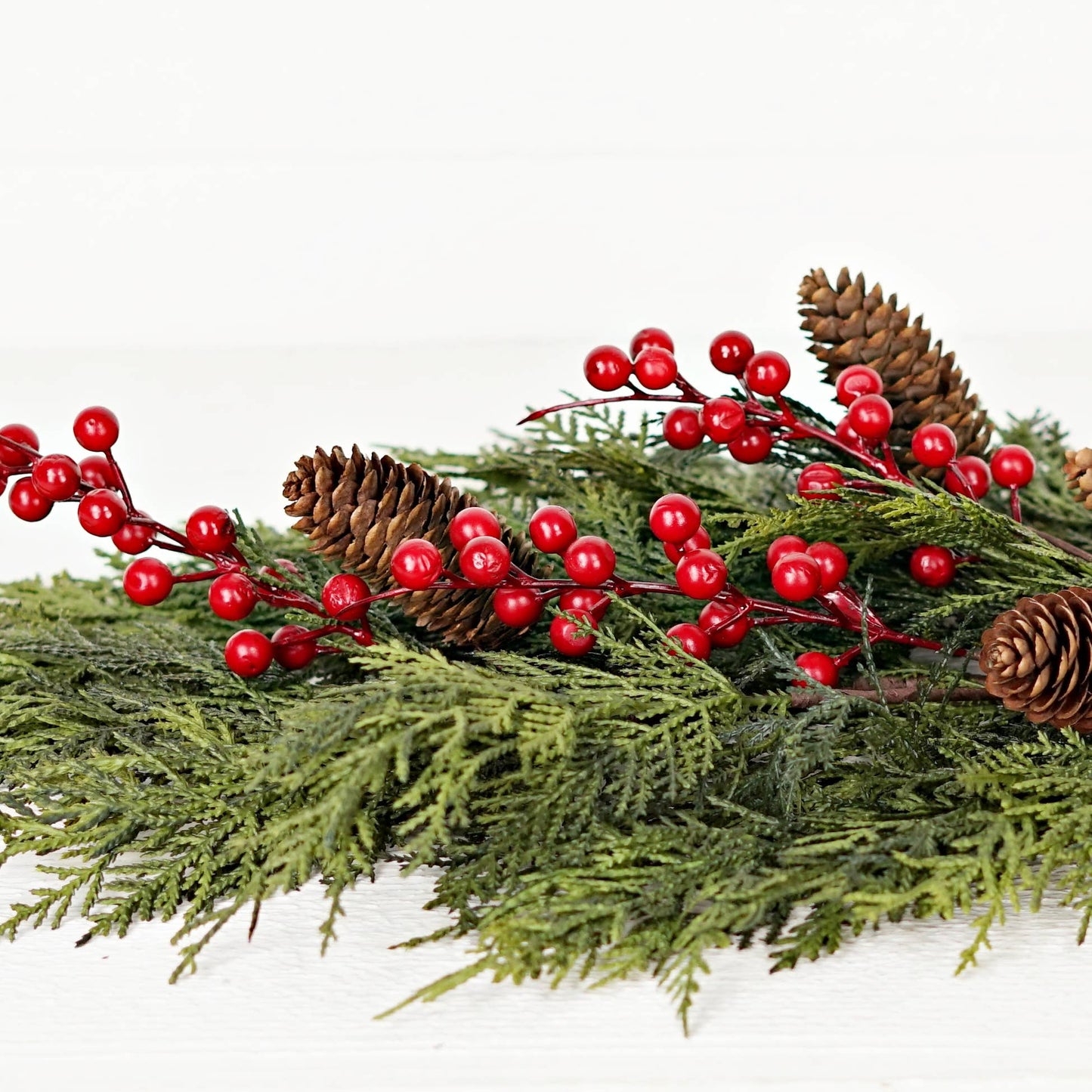 510053- 26inLx16inW Teardrop-Superior Real Touch Mix Cedar features lush green pine branches, natural brown pinecones, and red berry accents crafted from real touch cedar.