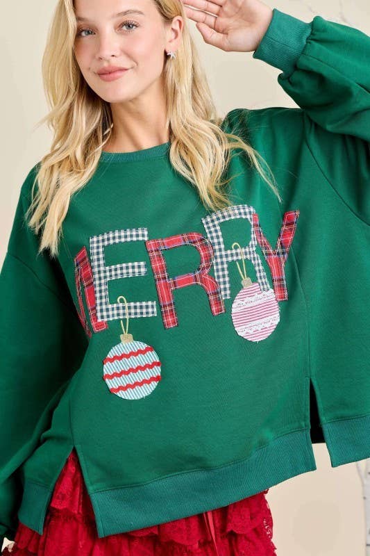 “Merry With Ornament Patchwork Oversized Long Sleeve Top” in hunter green with “MERRY” in plaid and two ornaments; available in sizes S-XXL.