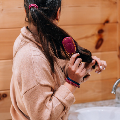 Mini Boar Bristle Hair Brush in Mulberry, shown in use; available in mini size.