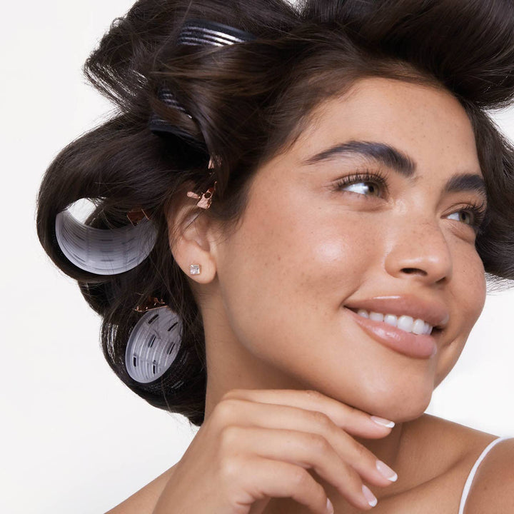 Ceramic Hair Roller 8pc Variety Pack shown creating voluminous hair; set includes multiple roller sizes for styling.