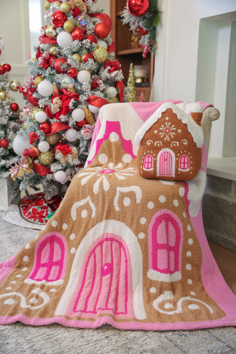 Gingerbread house pillow and matching throw blanket with pink and brown pattern.