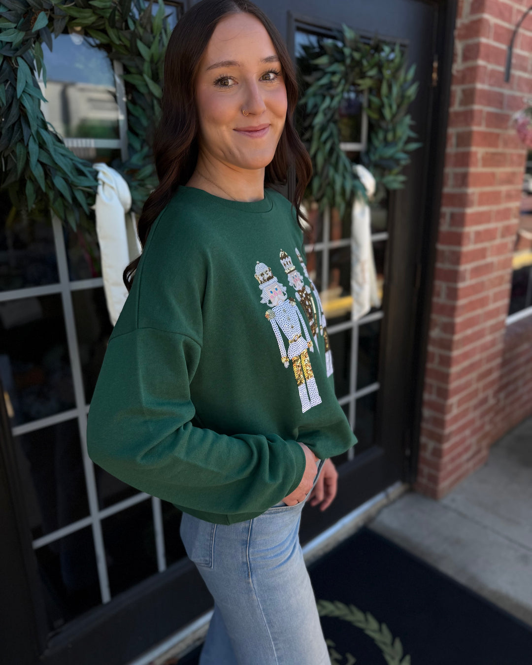 Dark green Alpine Nutcracker sequin sweatshirt with holiday graphic. Available in all sizes.