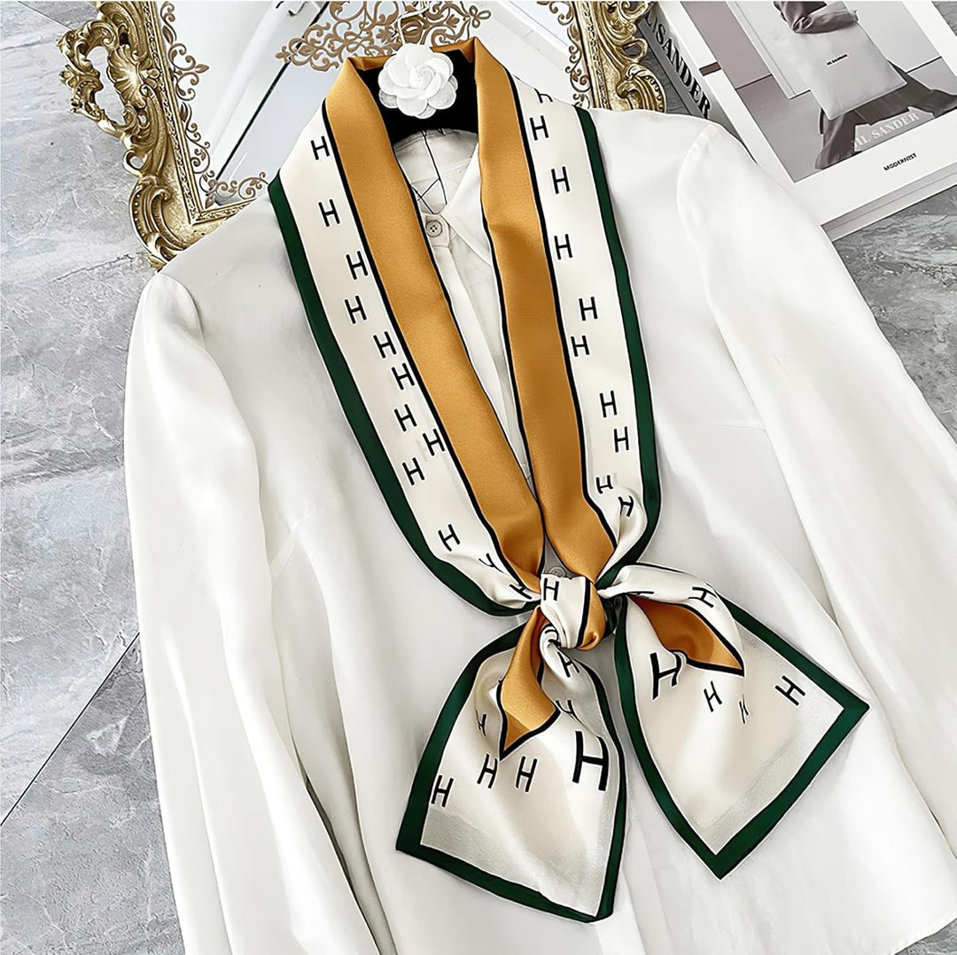White silk scarf with green borders, gold accents, and repeating "H" pattern. Available sizes: 70x70cm, 90x90cm.
