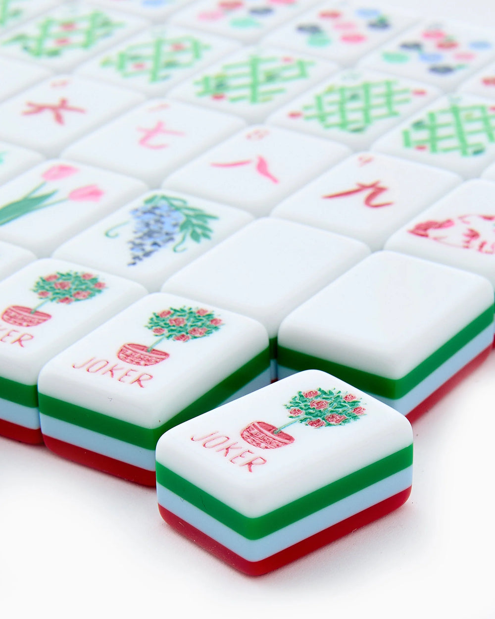 Nantucket Mahjong Tiles set shown close-up with a front tile displaying a red "JOKER" label and potted flower illustration; available sizes not specified.
