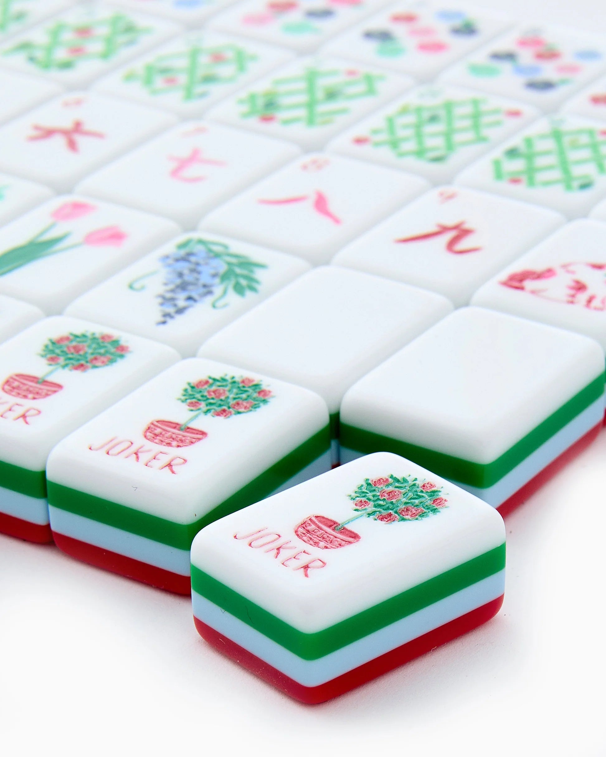 Nantucket Mahjong Tiles set shown close-up with a front tile displaying a red "JOKER" label and potted flower illustration; available sizes not specified.