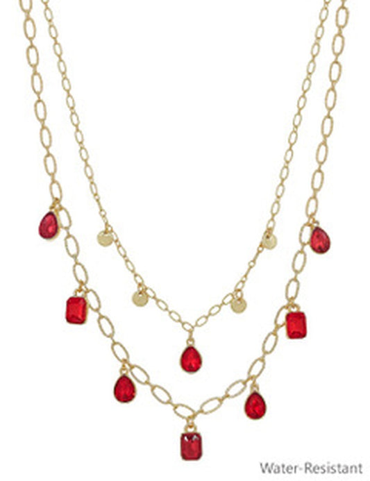 Double-layered gold necklace with round charms and ruby-red pendants. Water-resistant. Available in multiple sizes.