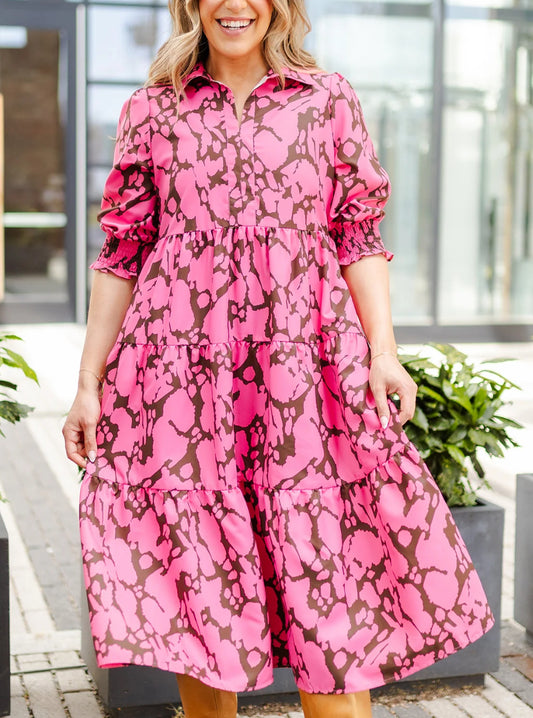 Eleanor Happy Place Pink Dress with bold brown abstract pattern. Features tiered design and gathered sleeves. Available in sizes XS, S, M, L.