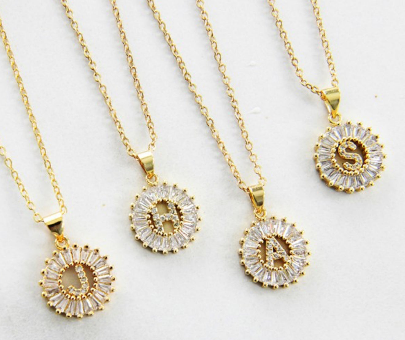 Stainless steel necklaces with gold CZ initial pendants (D, R, A, S); available in multiple sizes.