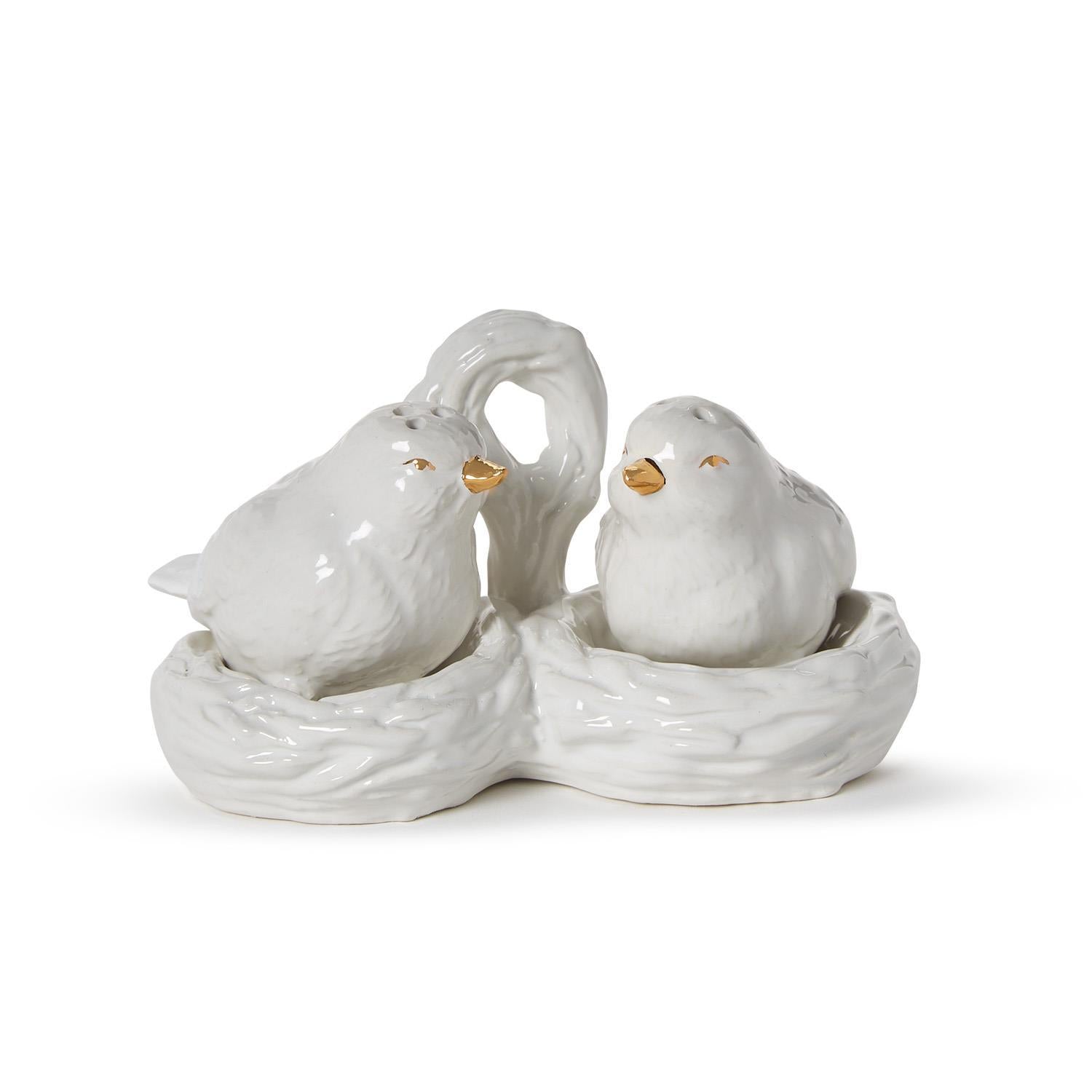 White ceramic bird salt and pepper shakers with gold details in a nest carrier with handle. Sizes: standard only.