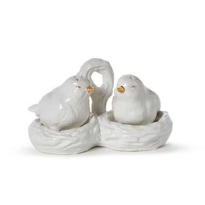 White ceramic bird salt and pepper shakers with gold details in a nest carrier with handle. Sizes: standard only.