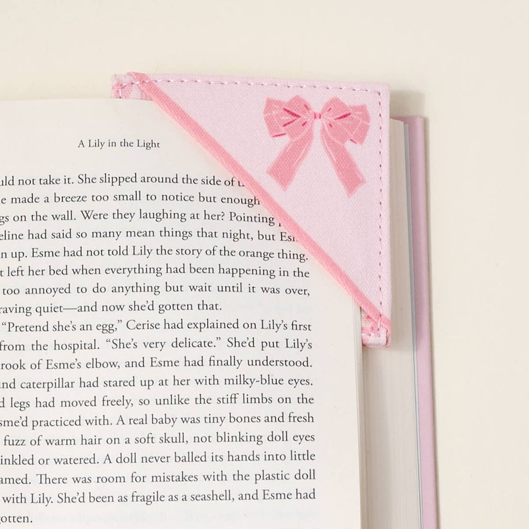 Pink quilted fabric bookmark with bow decorates book corner. Available in one size; fits standard book pages.