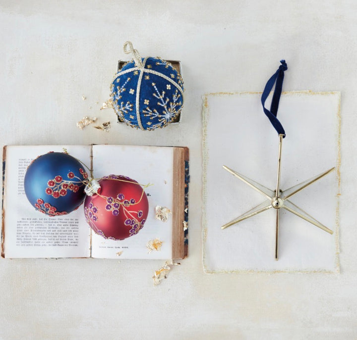 Three spherical Botanical Glass Ornaments with floral and snowflake designs.