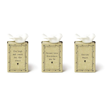 Dove Matchbox set includes three beige, matchbox-style decorative blocks, each with a white dove figurine on top and an uplifting message, accented with hearts. Available in one size.