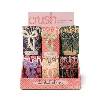 Six Crush Very Demure Bow Hair Clips in pastel and dark shades, available in one size, on patterned cards in a display box.