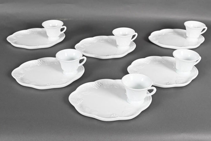 Set of six white milk glass snack plates and cups with scalloped edges and embossed pattern. Sizes: standard only.