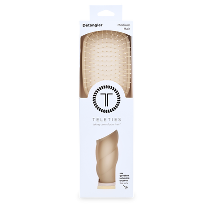 Tan Detangler Hair Brush for Medium Hair in white packaging labeled “Detangler” and “TELETIES,” with the tagline “taking care of your hair”; available in medium size.