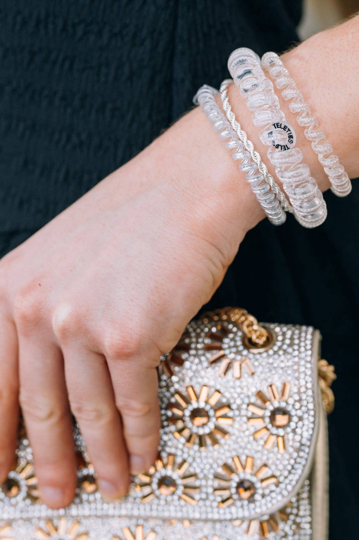 Silver Slay Spiral Hair Coils shown on wrist. Available in small, medium, and large. Stylish and functional hair ties.
