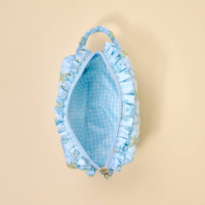 Small, light blue quilted cosmetic pouch with handle, zip closure, checkered wipeable lining. Available in one size.