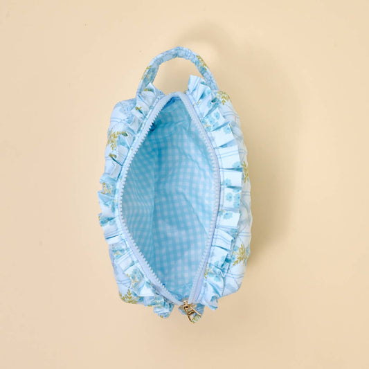 Small, light blue quilted cosmetic pouch with handle, zip closure, checkered wipeable lining. Available in one size.