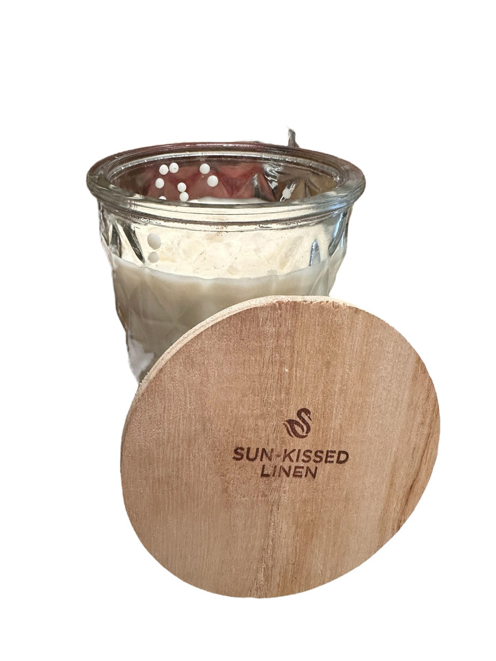 Timeless 12oz. Jar Candle with white soybean wax in glass jar, wooden lid engraved “SUN-KISSED LINEN.” Available in 12oz.