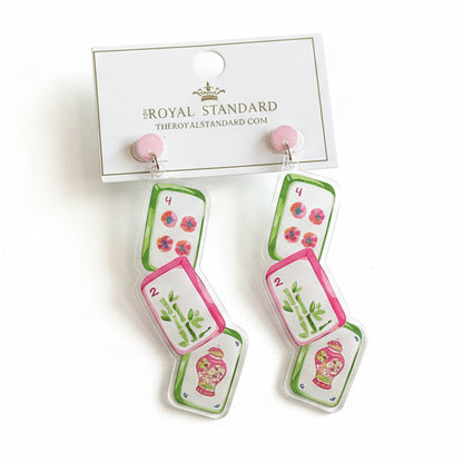 Lucky Tile Mahjong Earrings: statement earrings featuring three mahjong tile designs—flowers, bamboo, and a pink vase—on a white background. Attached to a card labeled “The Royal Standard.” Available in one size.