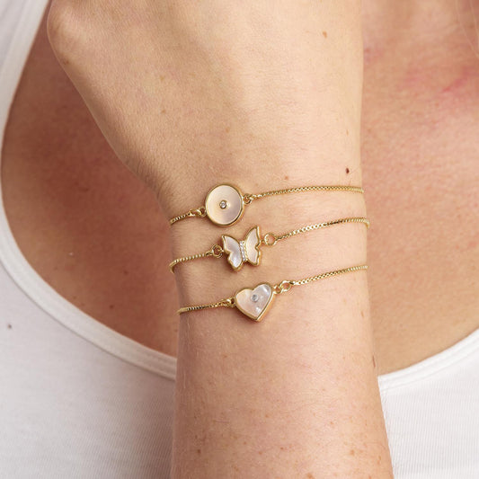 Pearlescent Adjustable Rhinestone Bracelet with round, butterfly, heart charms in white accents. Available in S/M, M/L.