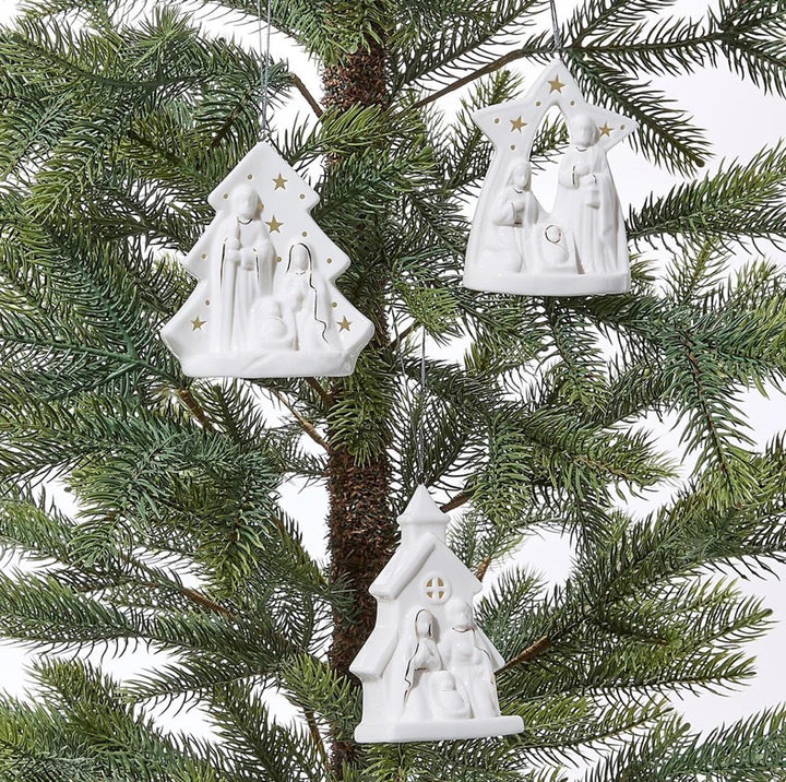 Three white, light-up Starry Manger Keepsake ornaments in tree, star, and church shapes with holy scenes.