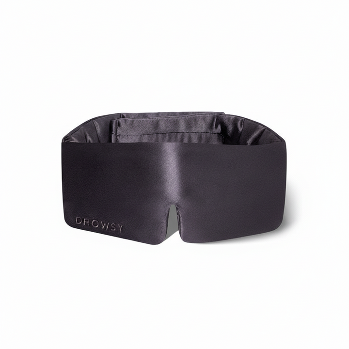 Black silk Drowsy Sleep Mask with "DROWSY" embroidery on one side. Available in standard and large sizes.