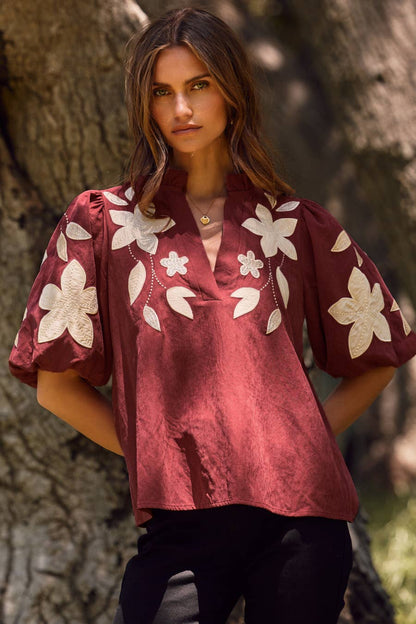 Washed Suede Top in camel with white floral applique on the chest and puffed sleeves; available in sizes XS-XL.