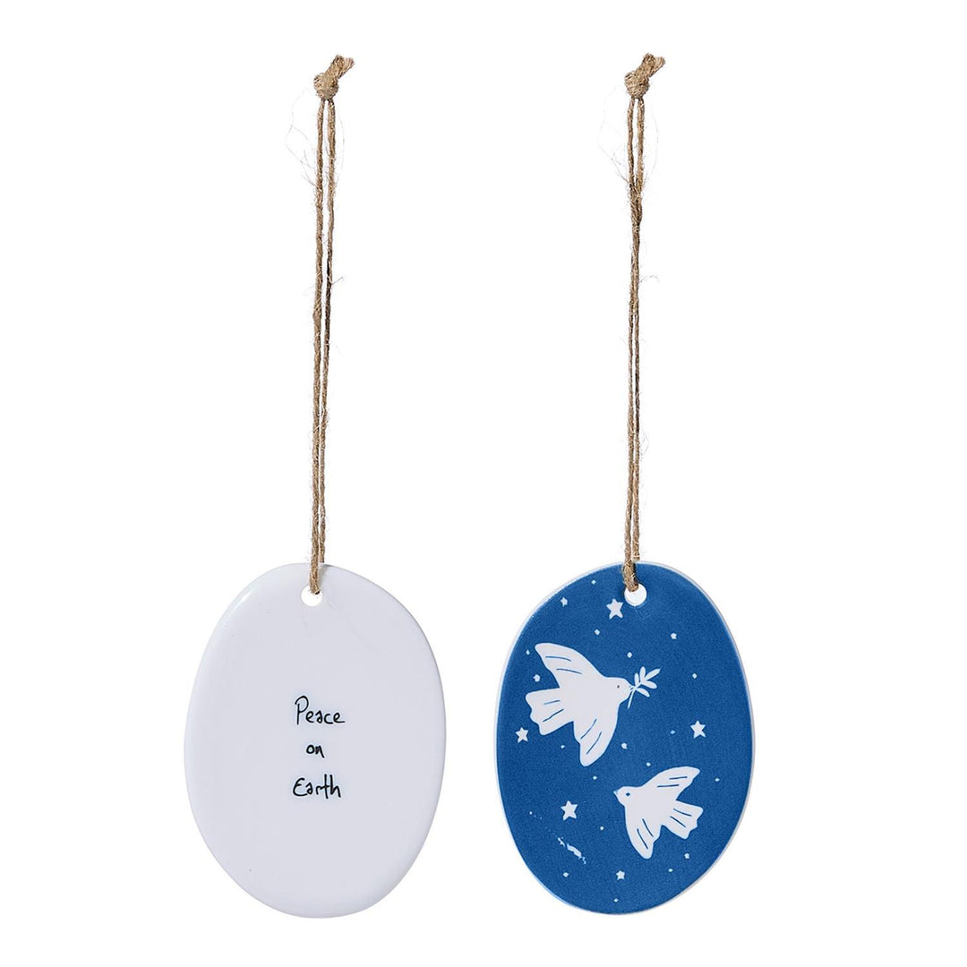 Two oval porcelain ornaments: one white with “Peace on Earth” text, one blue and white with doves and stars.
