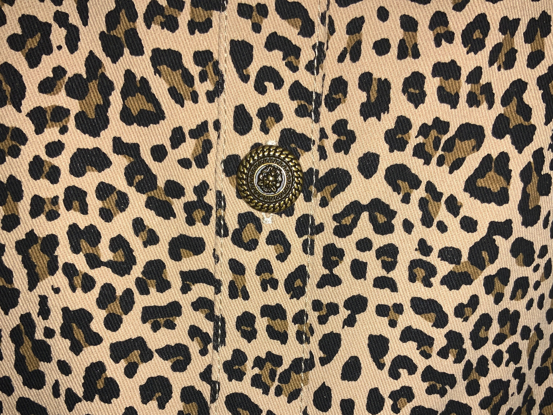 Leopard denim dress with a single ornate metal button on a central placket. Available in various sizes.