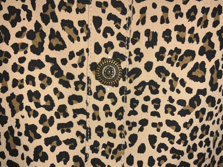 Leopard denim dress with a single ornate metal button on a central placket. Available in various sizes.