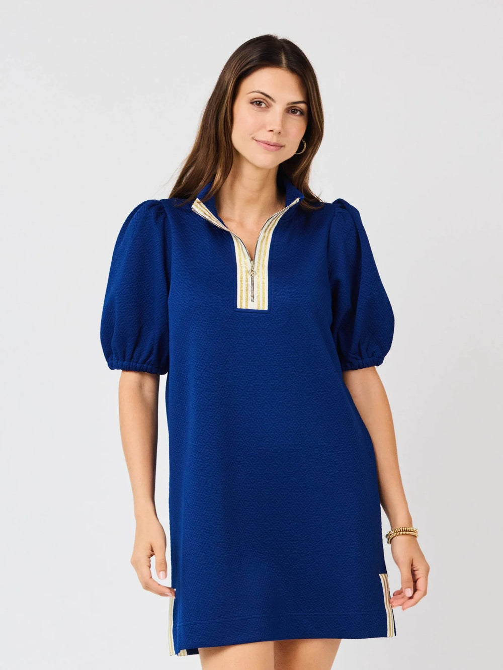 Andie Navy Dress with crosshatch jacquard, puff sleeves, gold-trimmed zip neckline. Sizes: XS-XL.