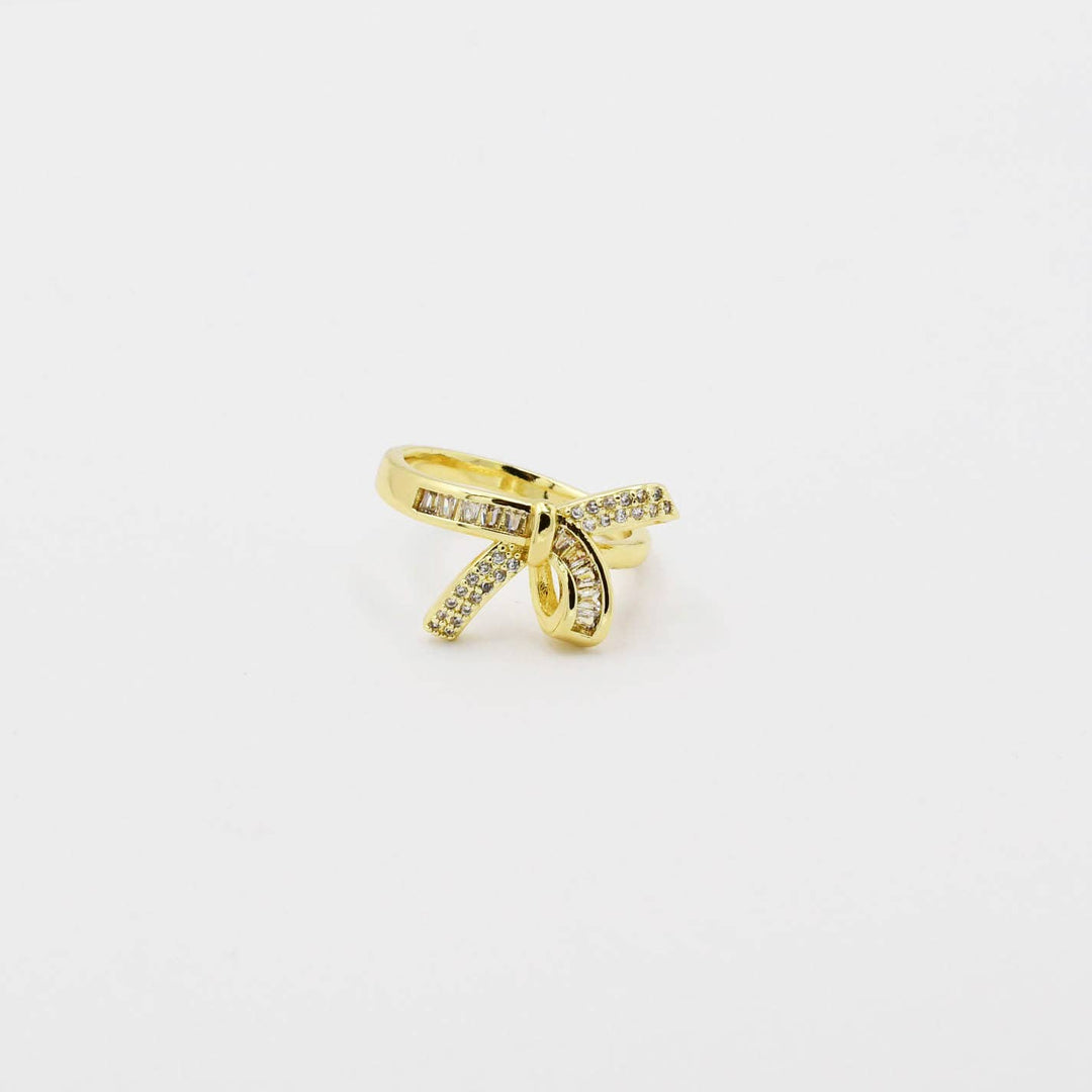 Pave Bow Gold ring: bow-shaped, gold-plated, clear gemstones. Available sizes: 6, 7, 8.