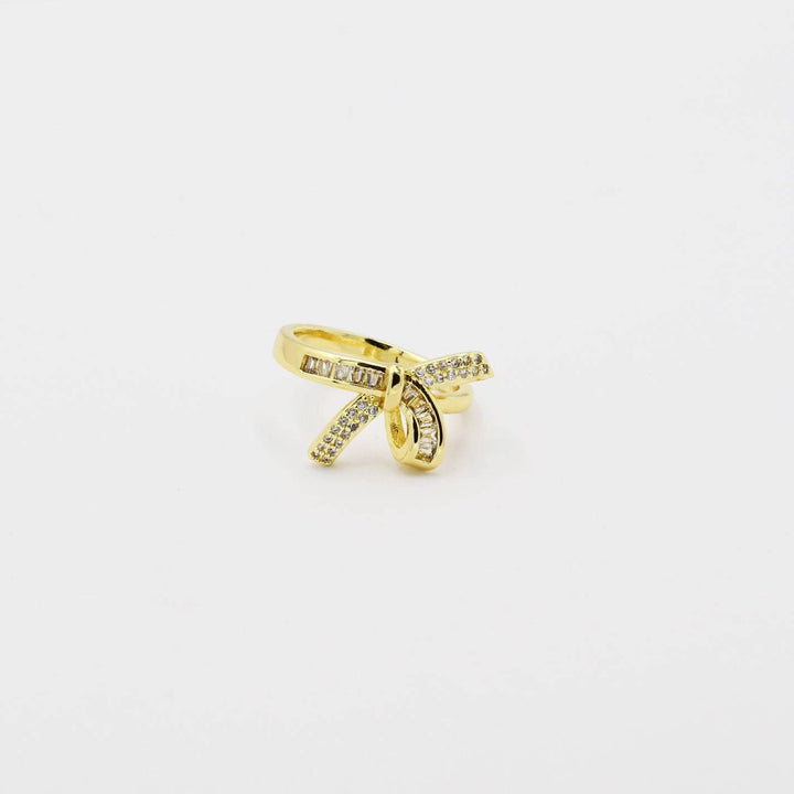 Pave Bow Gold ring: bow-shaped, gold-plated, clear gemstones. Available sizes: 6, 7, 8.