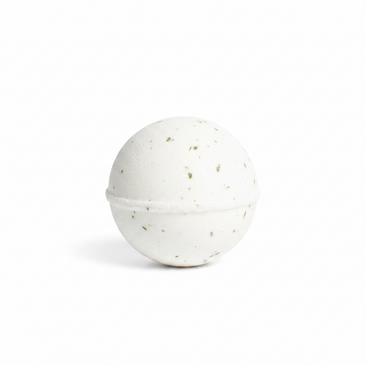 Spherical Winter Fir Bath Fizzer, Frosted Pine, white with green botanical pieces, fizzing in water.