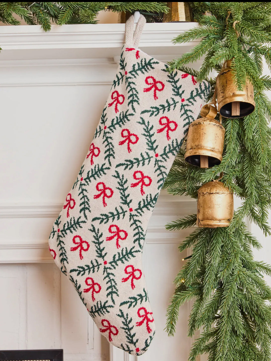 Holiday Trellis Stocking in cream knit with a green pine bough and red bow trellis pattern.